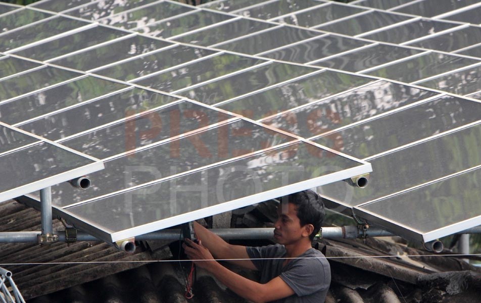 Ilustrasi. Seorang tehnisi mengecek panel instalasi pembangkit listrik tenaga surya ( solar sel) di SMPN 12 Jakarta Selatan, 26 Februari 2014. Indonesia Press Photo/Dadang Tri